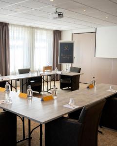 阿尔克马尔Hotel Alkmaar的一间会议室,配有桌椅和屏幕