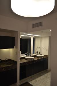 布宜诺斯艾利斯Hotel BA Abasto的一间带三个水槽和大镜子的浴室