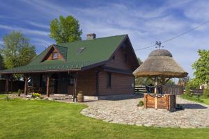 JaminyDom pod Lipą的一座带茅草屋顶的大型木制房屋