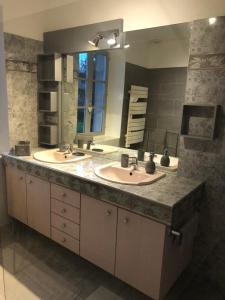 TrévigninVilla Evalou de 240 m².的一间带两个盥洗盆和大镜子的浴室