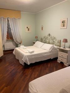 维泰博AL MANDORLO Casa Vacanze的一间卧室设有两张床,铺有木地板