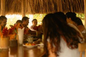 伯里塔卡Playa Bonita Hotel EcoCabañas Tayrona的一群坐在餐厅桌子上的人