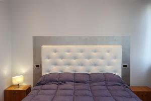 都灵Casa sotto le stelle的一间卧室配有一张紫色床和一个大床头板