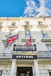 伦敦Huttons Hotel, Victoria London的酒店前阳台的两面英国国旗