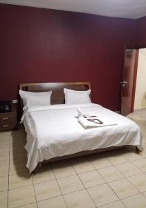 班基La Couronne Suites的一张配有白色床单和白色枕头的大床