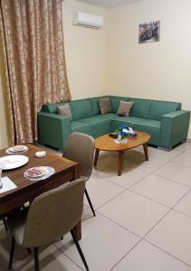 班基La Couronne Suites的客厅配有绿色沙发和桌子