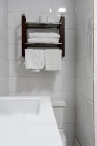 昆卡昆卡酒店的白色浴室,架子上配有白色毛巾