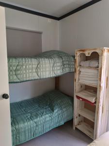 特立尼达岛Casita de Piedra 12 y 13的小型客房设有两张双层床,配有梯子