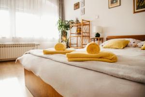 斯拉沃尼亚布罗德Soba Gloria的一间卧室配有两张带黄毛巾的床。