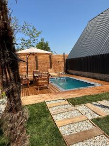 萨卡里亚Sapanca360bungalows的后院设有游泳池、桌子和遮阳伞