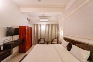 古瓦哈提Alhanney Housing的一间酒店客房,配有一张床和一台电视