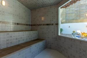 托兰克索Villa Alexandre Pousada - Trancoso的带浴缸和窗户的浴室