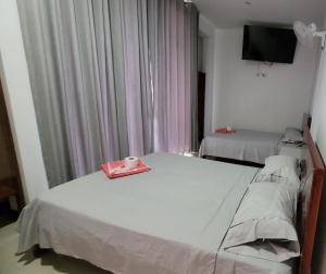 廷戈玛丽亚Hospedaje Vista Paraíso的一间带两张床和电视的卧室