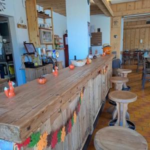 圣皮埃尔堡Auberge des Charmettes, chez Chantal et Yves的餐厅内带南瓜的木制酒吧
