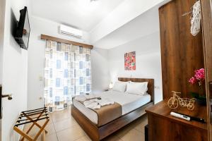 基萨莫斯Stelios & Stavros Apartment的一间卧室设有一张床、一台电视和一个窗口。