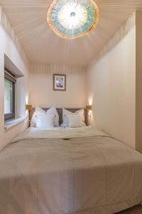 鲍道乔尼特尔代米茨HeLo Bungalow的一间卧室设有一张带天花板的大床