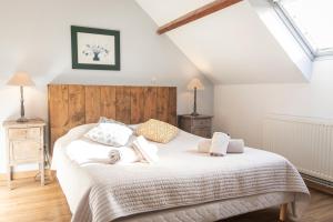 菲耶讷La Ferme Du Grand Air的一间卧室配有带白色床单和枕头的床。