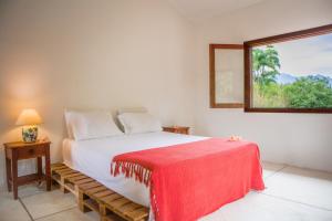 卡舒埃拉斯迪马卡库Guest House Fazenda do Francês & Culinária Francesa的一间卧室配有一张床铺,床上铺有红色毯子