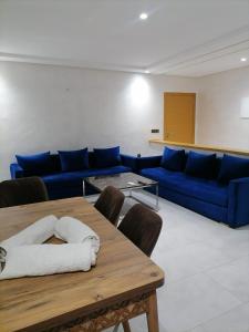 丹吉尔Apartment chakira family only的客厅配有蓝色的沙发和桌子