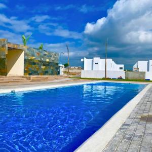 曼塔Casa Familiar a Pasos del Mar Playa y Felicidad的大楼前的蓝色海水游泳池