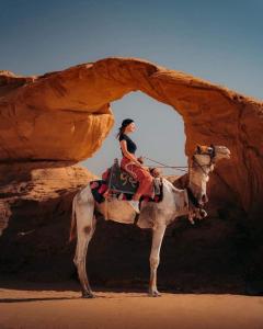 瓦迪拉姆Hakuna matata desert camp的一位在沙漠骑骆驼的女人