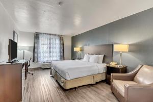 盐湖城Clarion Inn Salt Lake City Airport的酒店客房,配有床和沙发