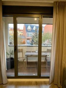莱昂Apartamento Entero 2 HABITACIONES的推拉玻璃门,窗户前配有桌子