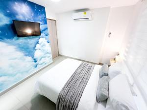 卡塔赫纳Hostal El Cielo的卧室配有一张床铺,墙上配有电视
