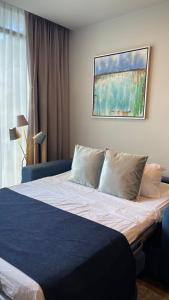 圣何塞Cozy apartment with terrace, SJ Cosmopolitan Tower的一间卧室配有一张带蓝色床单和枕头的床。
