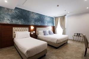罗马Esposizione Luxury Rome的一间卧室设有两张床,墙上挂着一幅画