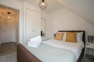 温莎ENTR - Modern Apartments in Windsor with Parking的一间卧室配有带白色床单和枕头的床。