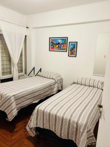 圣米格尔·德·图库玛Departamento Céntrico Tucumán 1B的白色墙壁客房的两张床