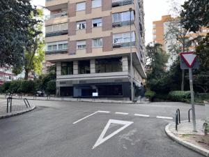 马德里Rooms Luxury Madrid的大楼前的一个空停车位