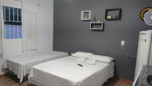 伊克斯雷玛Hospedagem Santo Agostinho的一间卧室设有两张床、一个窗口和一台冰箱