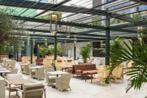 埃斯托利尔EVOLUTION Cascais-Estoril Hotel的餐厅设有桌椅和玻璃天花板。