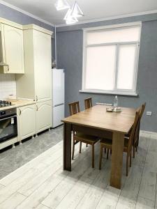 阿特劳# 268 Светлая и уютная квартира的厨房配有桌椅和冰箱。