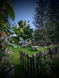 佩尔武Auberge Saint Antoine的花园设有木栅栏、桌子和鲜花