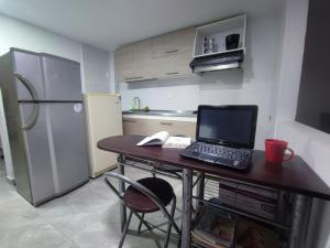 马尼萨莱斯Hostal Ninfa del Mar的厨房配有一张桌子,上面有一台笔记本电脑