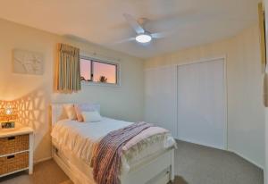 Burnett HeadsEdge of Oaks Beach的一间卧室配有一张床和吊扇