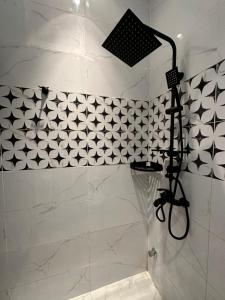 利雅德شقة أنيقة في العليا的浴室铺有黑白瓷砖,设有淋浴。