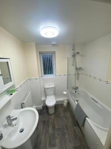 利物浦Lovely 2 bed apartment in Crosby的浴室配有盥洗盆、卫生间和浴缸。