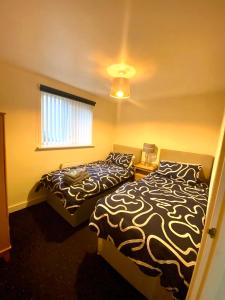 利物浦Lovely 2 bed apartment in Crosby的一间卧室设有两张床和窗户。