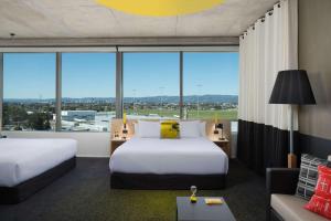 阿德莱德阿德莱德机场阿图拉酒店的酒店客房设有两张床和大窗户。