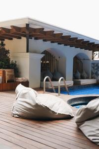 瓦哈卡市Los Pilares Hotel的一个带枕头的木甲板和一个游泳池