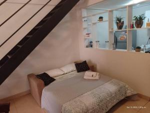 圣米格尔·德·图库玛Loft Plaza Belgrano的一间卧室设有一张床和一个楼梯