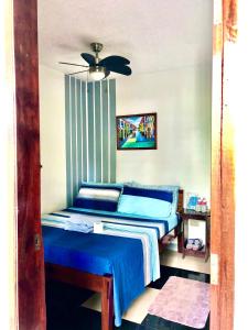 爱妮岛Hidden Garden Pensione的一间卧室配有蓝色的床和吊扇