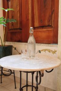瓦哈卡市Los Pilares Hotel的桌子上的玻璃瓶,上面有玻璃杯