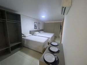 若昂佩索阿Guest Manaíra Apart Hotel的酒店客房设有两张床和盥洗盆