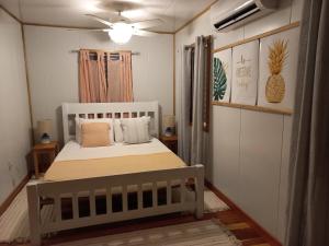 圣伊格纳西奥Mariposa Jungle Lodge的卧室配有白色的床和枕头。