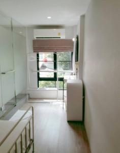 曼谷贝德普勒蒂旅舍的客房设有白色冰箱和窗户。